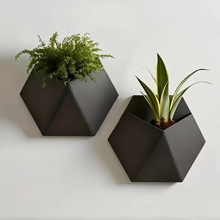 Le pot de fleurs hexagonal noir à fixer au mur a un design simple et unique. Sa structure perforée facilite l'installation et est robuste.