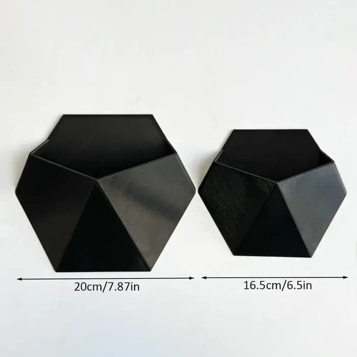 Le pot de fleurs hexagonal noir à fixer au mur a un design simple et unique. Sa structure perforée facilite l'installation et est robuste.